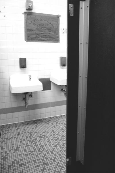 From the inside of the stall, the hinges are all that’s left of a door. 